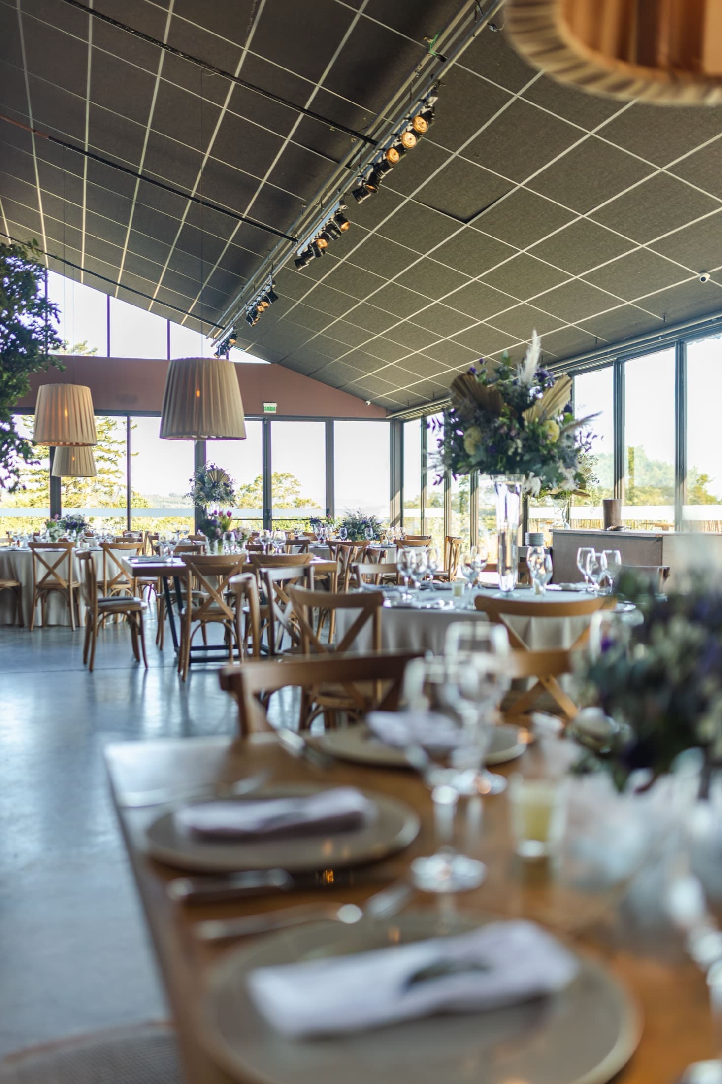 A hotel function room laid for a large event, round tables set and empty.